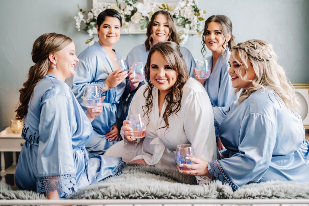 bridal party toasting champagne in matching robes while getting ready