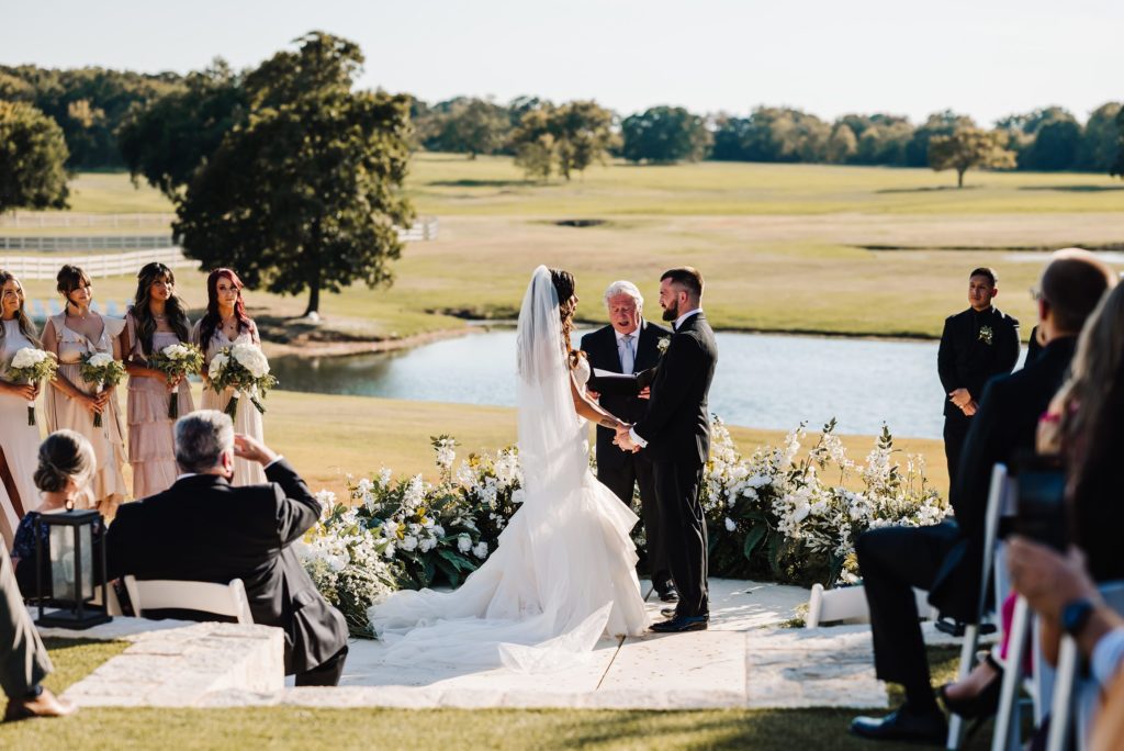 bride and groom exchanging wedding vows during wedding ceremony at Bella cavalli events in Aubrey, texas