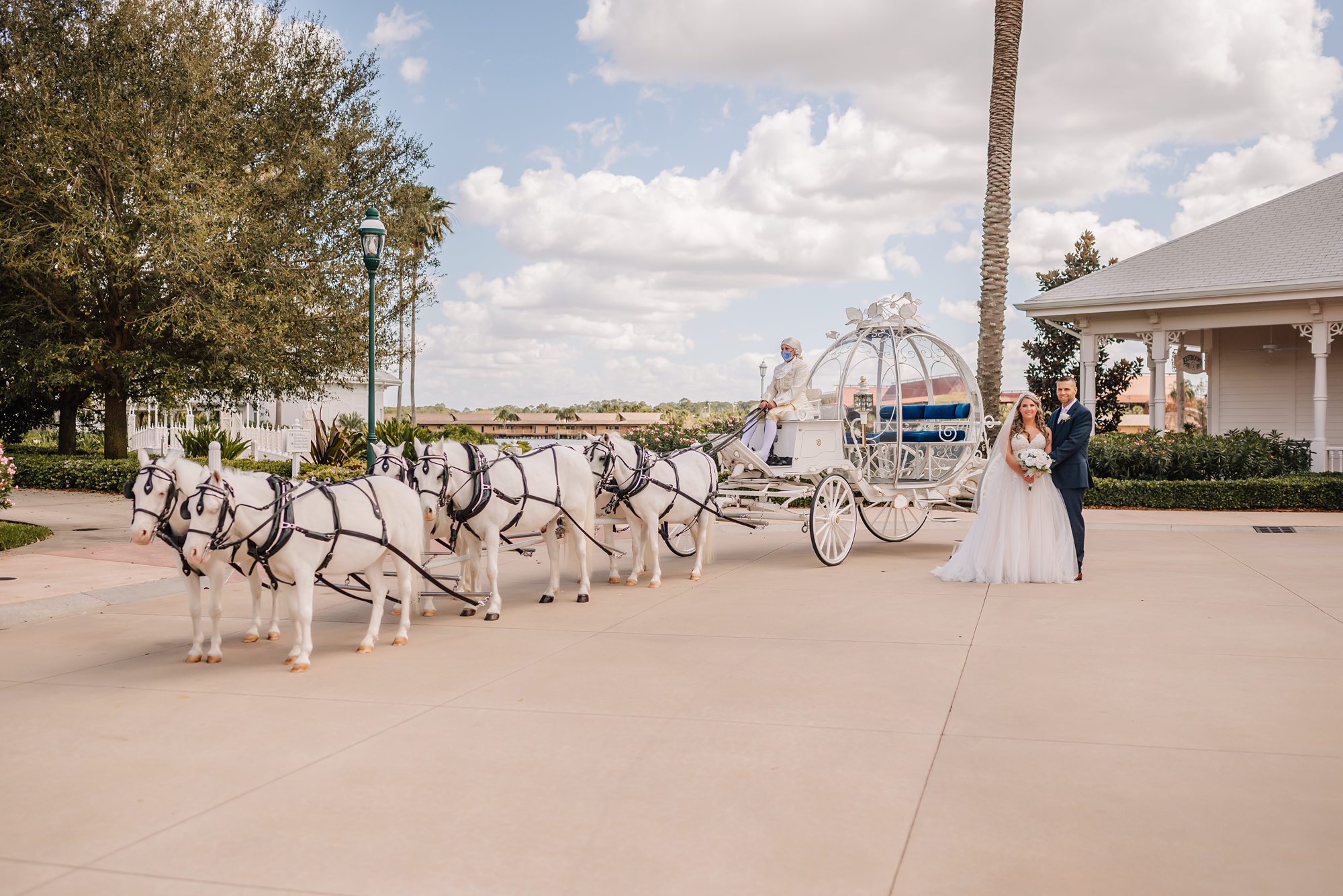 bride and groom with cinderella's carriage