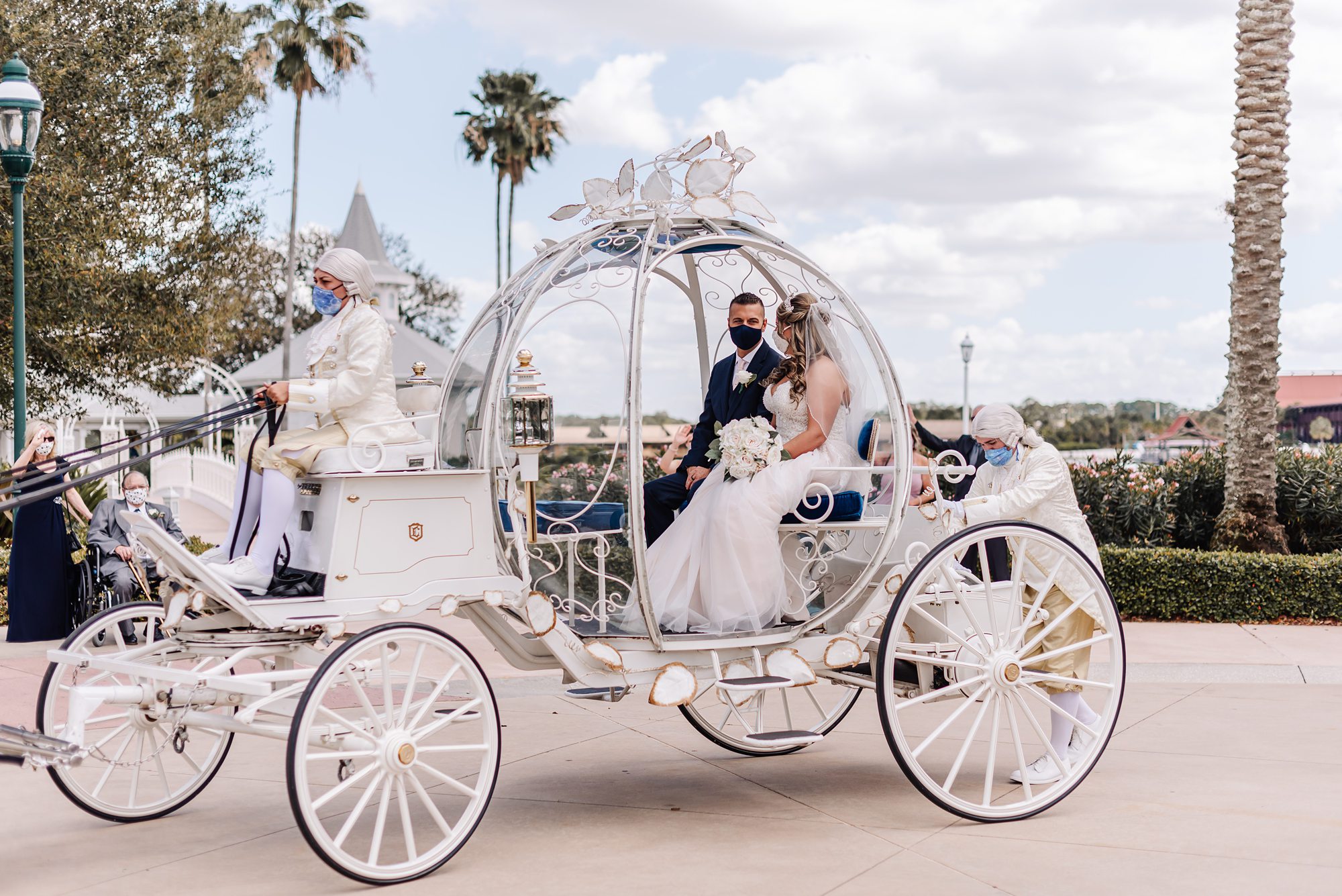 bride and groom depart in cinderella's carriage