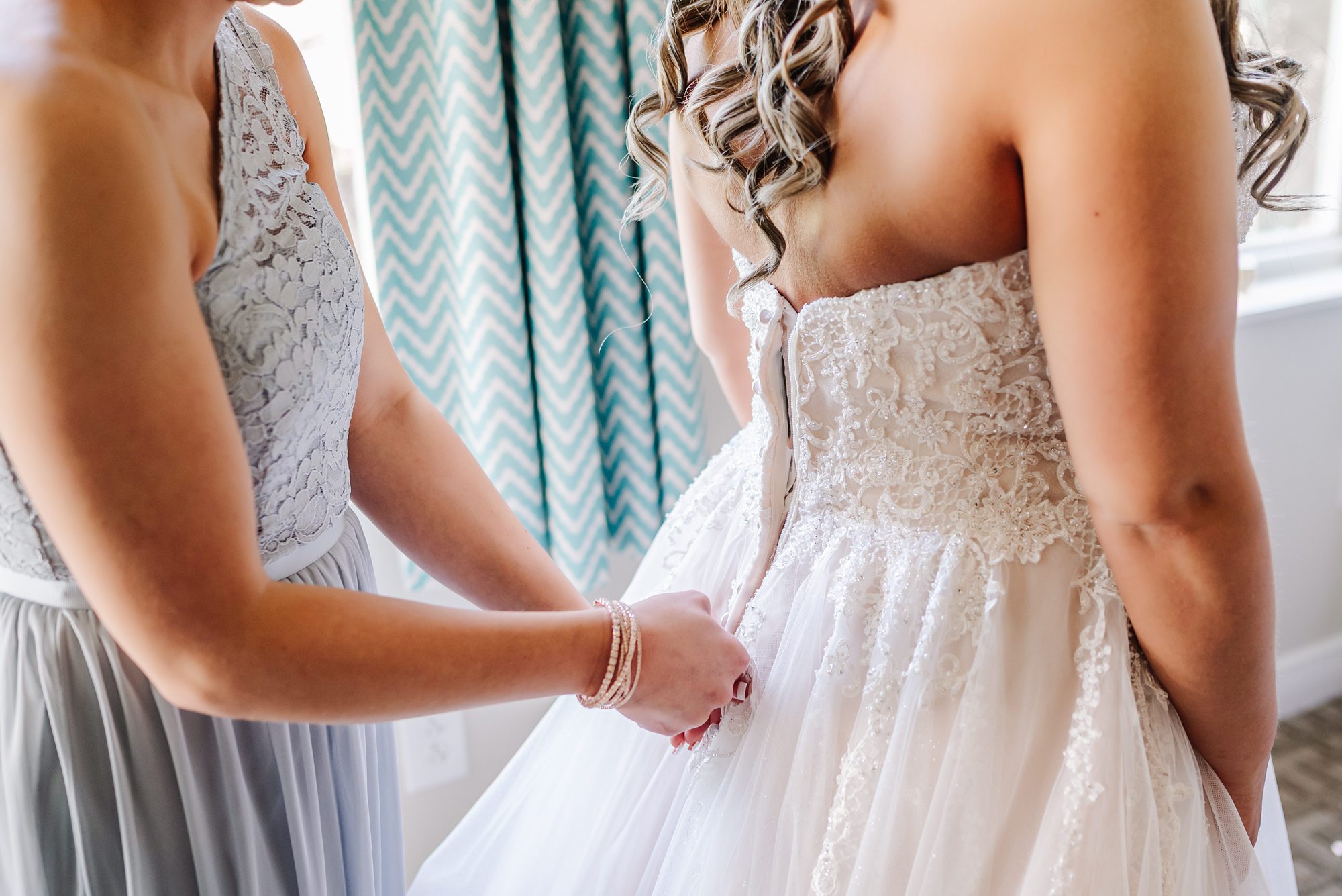 maid of honor zipping brides dress
