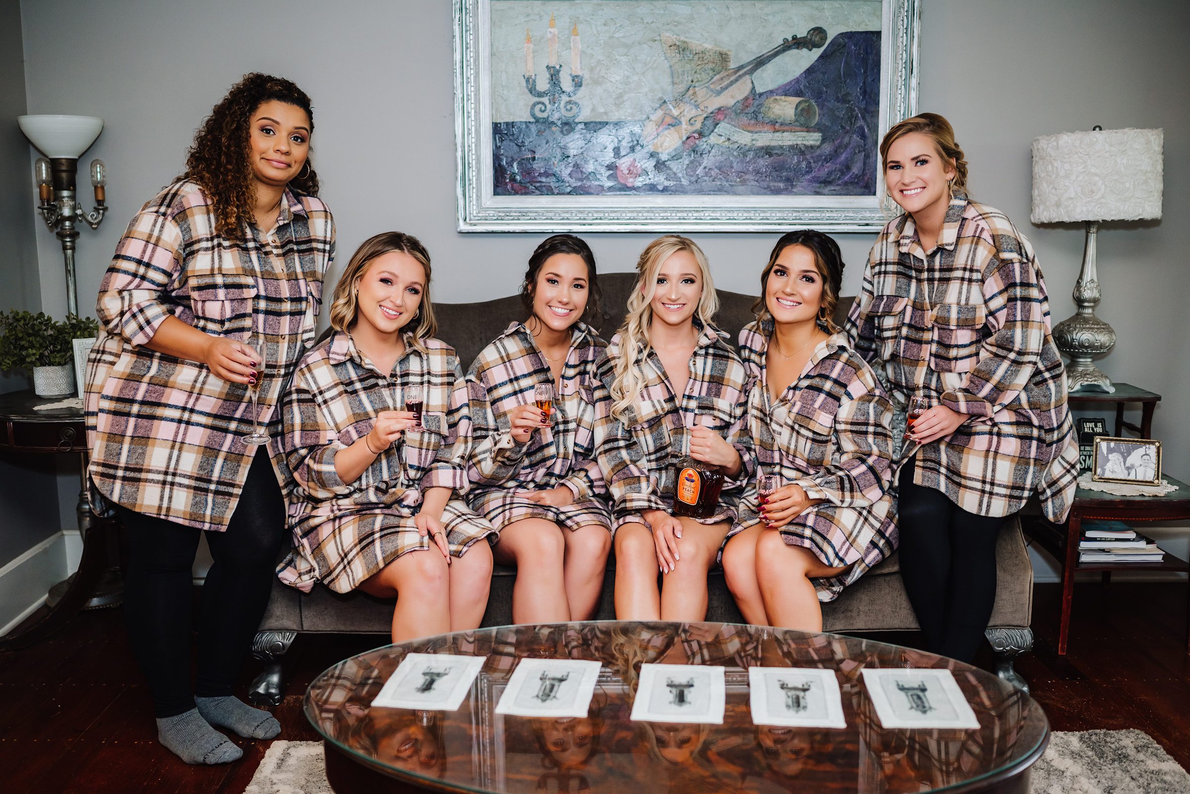 bridal party in matching flannels toasting