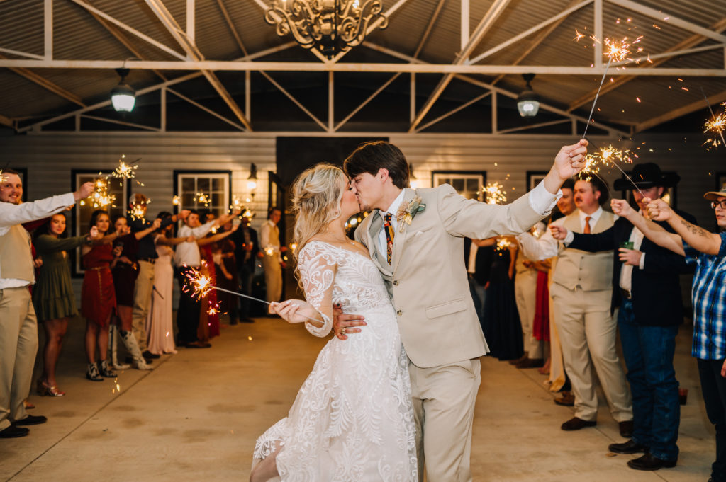 bride and groom kissing during sparkler exit