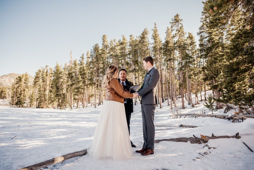 bride and groom sharing vows during intimate elopement in a snow filled Rocky Mountain national park 