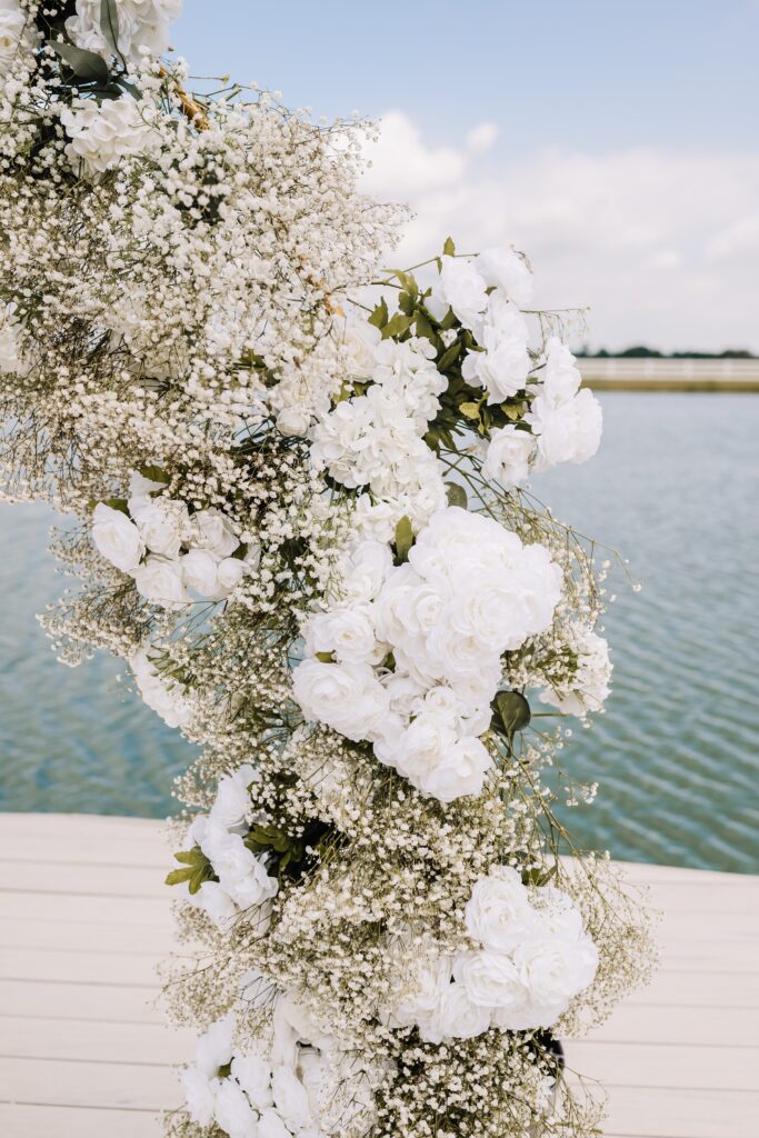 white roses and baby's breath wedding ceremony arch